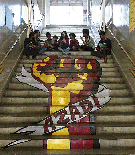 Graffiti with azadi written on a raised fist that students have drawn on the iconic staircase at Presidency University. 

