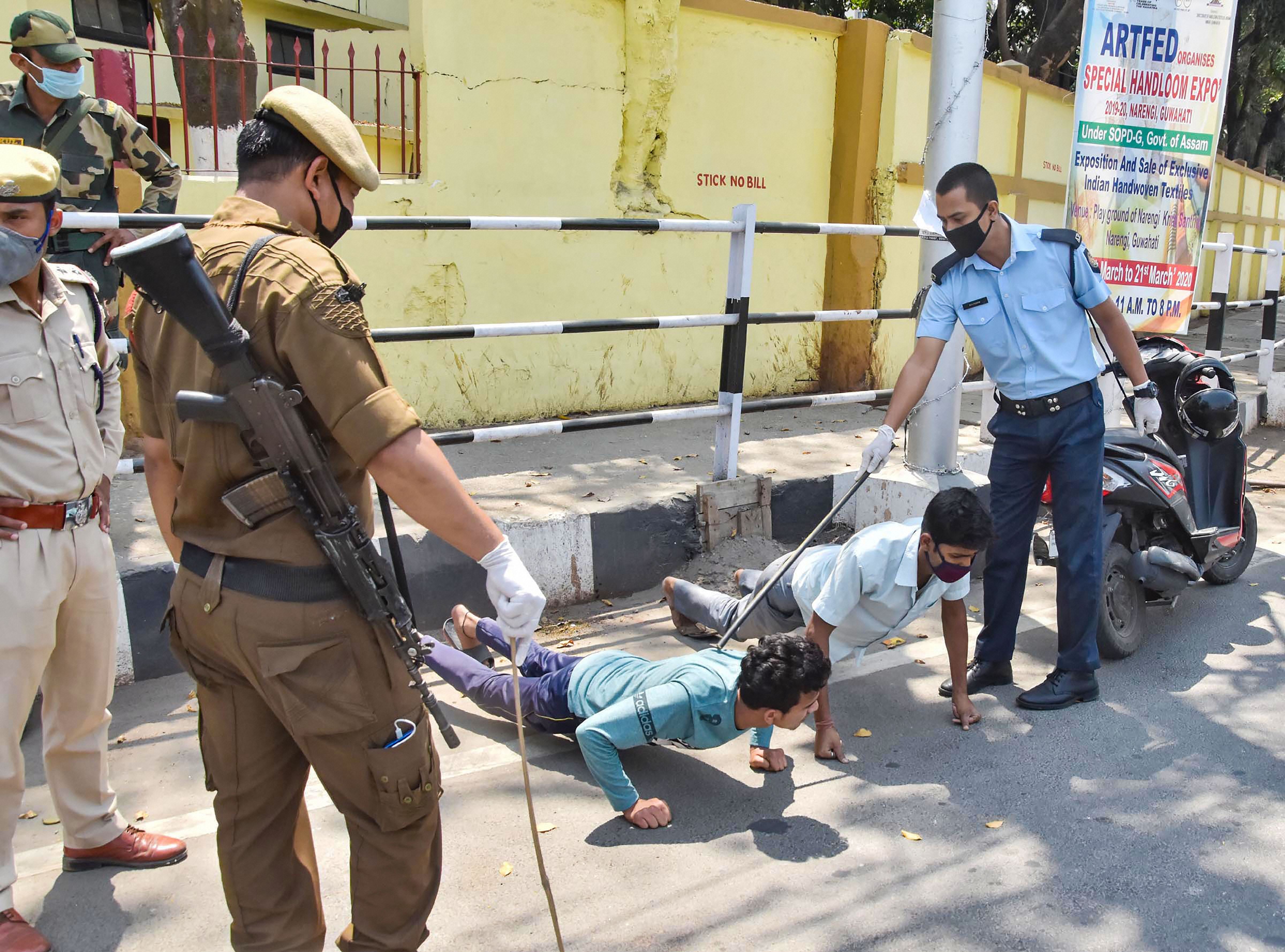 Police personnel punish commuters for flouting nationwide lockdown in the wake of coronavirus outbreak, in Guwahati, Saturday, April 4, 2020