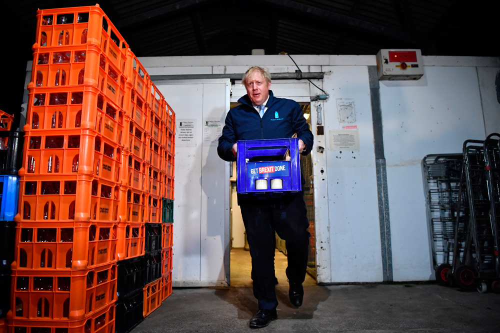 Boris Johnson in Leeds on December 11 carries a crate of milk bearing the Conservative Party campaign slogan on the last day of campaigning ahead of Thursday's general election