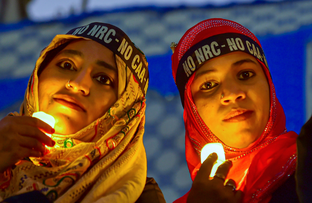 Muslim women hold LED-bulb lights during a protest against CAA, NRC and NPR, in Bangalore, Friday, January 24, 2020. 