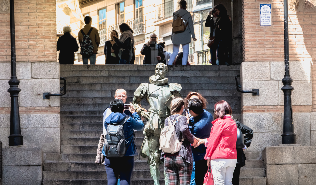 Tourists taking pictures of the Statue of Miguel de Cervantes near the main square of Toledo, Spain