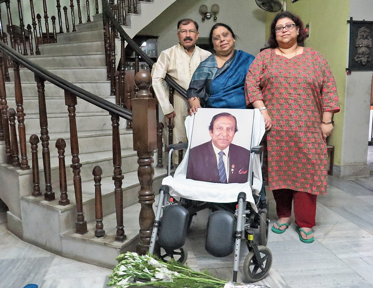 Brother Prasun and daughters Paula and Purna with the wheelchair where PK Banerjee would sit in his drawing room.