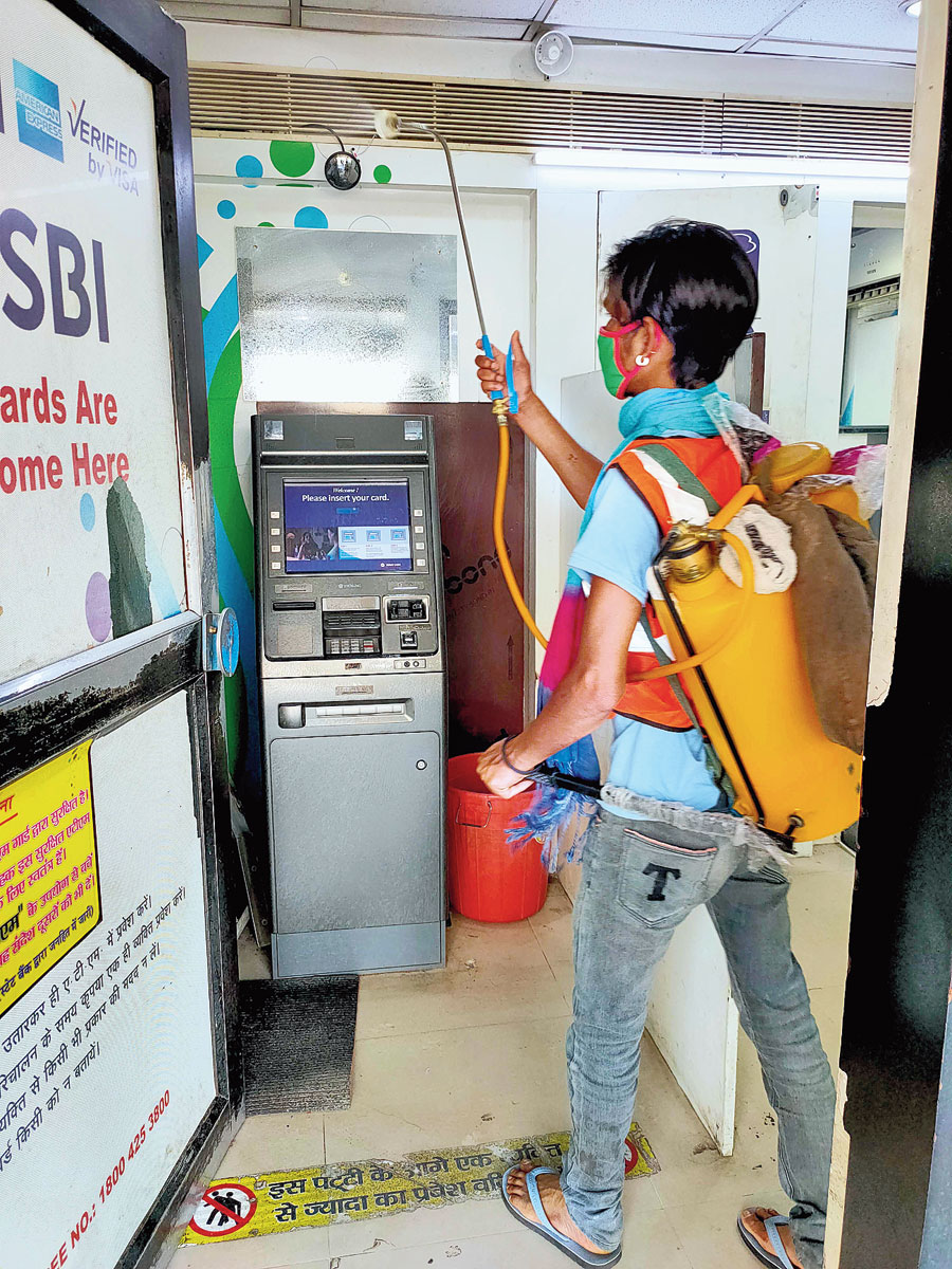 An RMC employee sanitises the ATM machine at HB road in Ranchi on Friday. 
