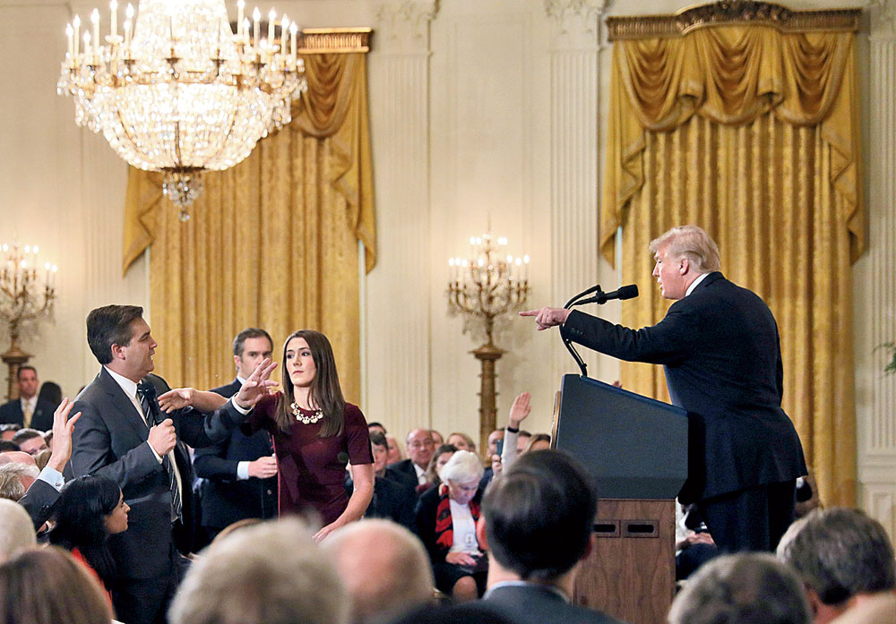 A White House intern (third from left) reaches for the microphone held by CNN’s Jim Acosta (extreme left) as he questions President Donald Trump (right) during the news conference at the White House on November 7, 2018. 
