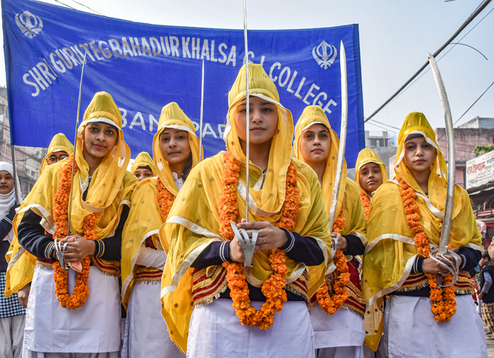 Girls dressed as Panj Pyaras participate in a procession ahead of the birth anniversary of Guru Gobind Singh Ji, in Prayagraj
