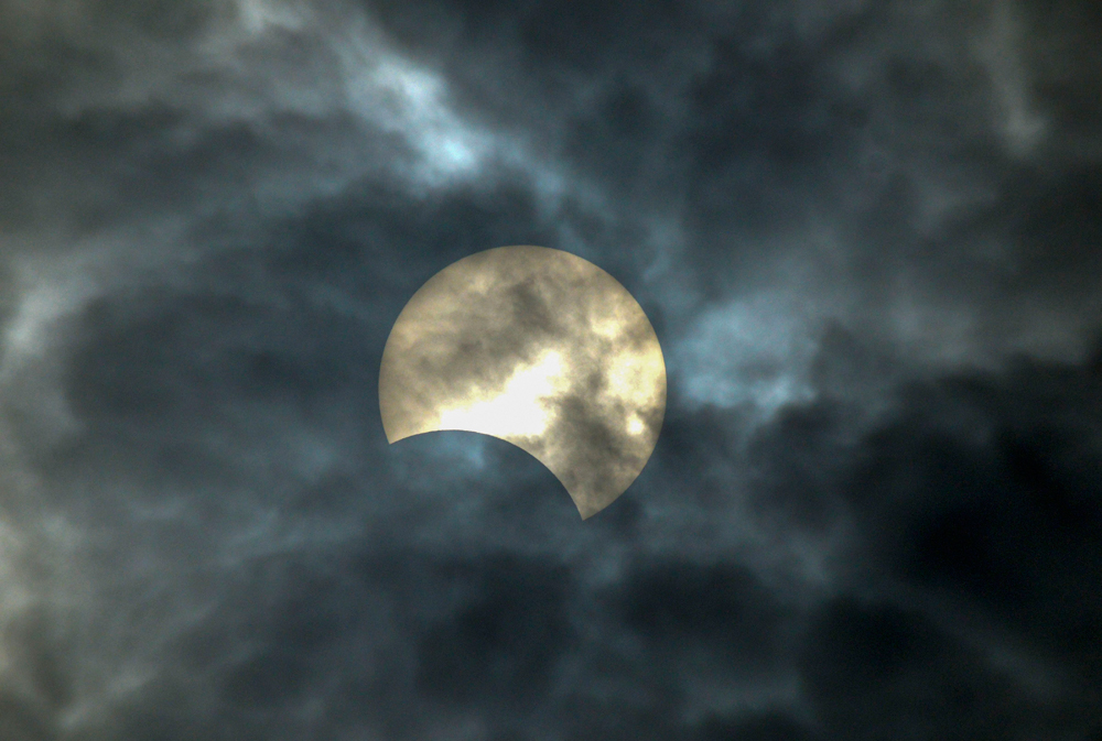 A view of the solar eclipse as seen in the cloudy sky from Karad, Maharashtra, on December 26