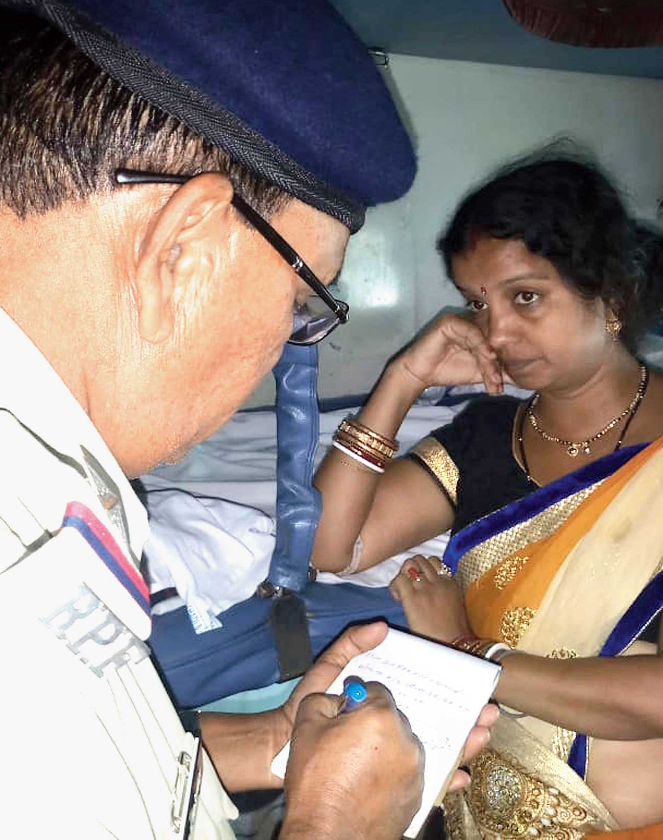 An RPF officer notes a passenger’s complaint  aboard Rajdhani Express in Gomoh station on Sunday. 


