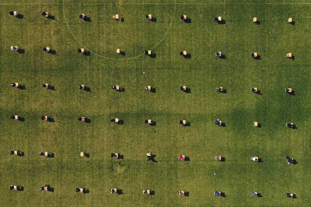 Applicants take written examination during a recruitment test for Ansan Urban Corporation at the Wa stadium in Ansan, South Korea, Saturday, April 4, 2020. The corporation decided to held their recruitment test at the outdoor stadium as part of precaution against the new coronavirus and also all applicants had to wear face masks and had their temperature checked. South Korea on Saturday extended for two weeks guidelines urging people to stick to social distancing.