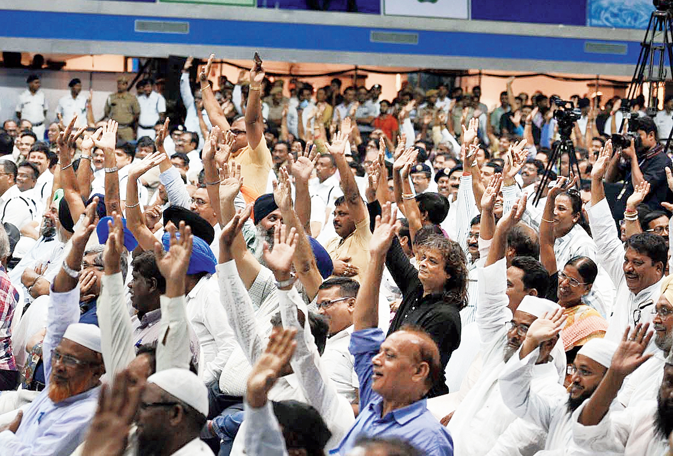 People in the audience at Netaji Indoor Stadium raise their hands in support of the proposal.