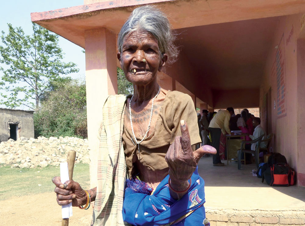 An 80-year-old woman flashes her inked index finger after casting her vote at Kundo village under Lohardaga constituency on Monday. 