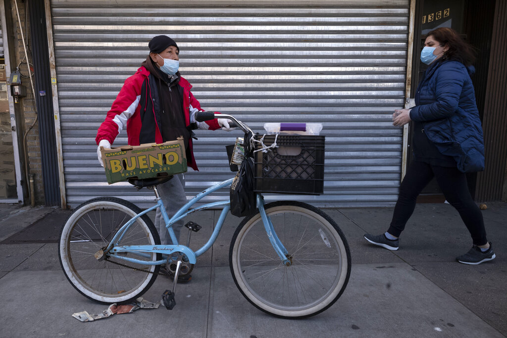 A man balances boxes of food that he picked up from Masbia Soup Kitchen, Thursday, March 26, 2020 during the coronavirus pandemic in the Brooklyn borough of New York.