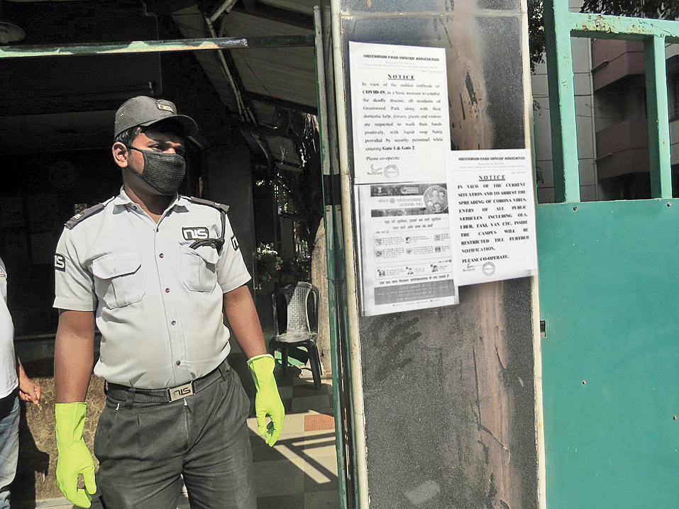 A gloved and masked security guard at the entrance to Greenwood Park.