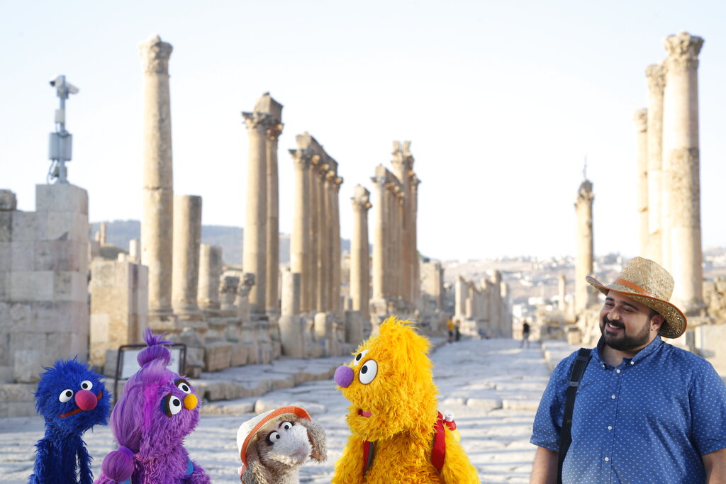 This image released by Sesame Workshop shows, from left, Grover, Basma, Ma'zooza and Jad with Rami Delshad, who portrays Hadi in 