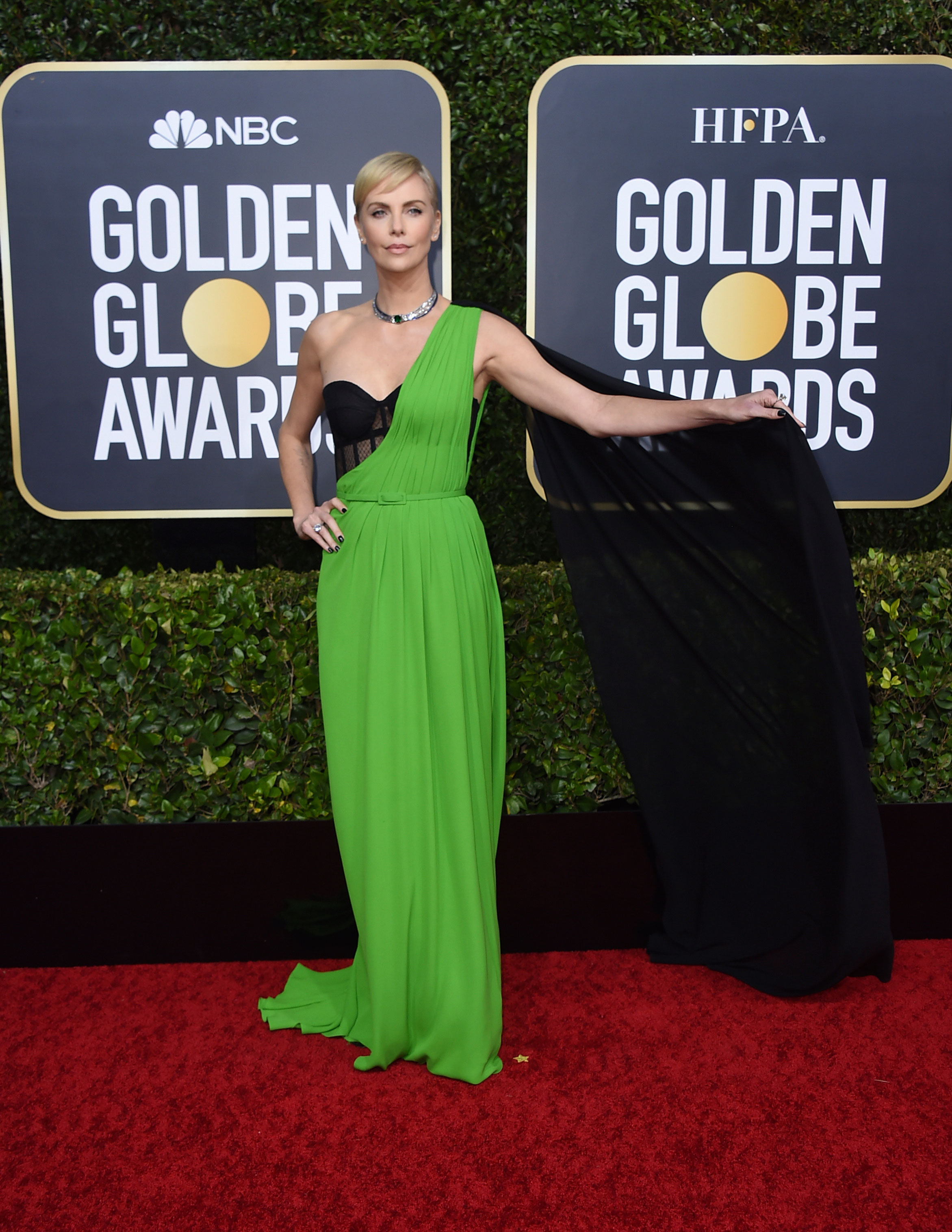 Charlize Theron’s minimalist look made us go ‘wow’! At 44, the Bombshell actress slayed in a one-shoulder green Dior gown with a flowy black cape that she wore with a lacy black corset and a tiny belt in the same green shade accentuating her tiny waist.