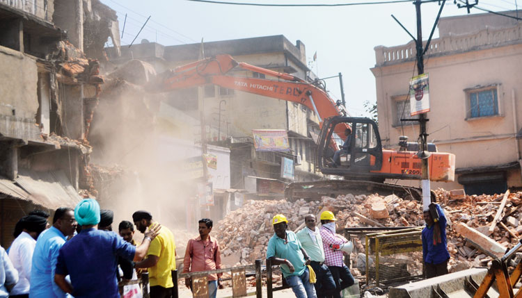 An illegal building being pulled down during the eviction drive at Jugsalai level crossing in Jamshedpur on Friday
