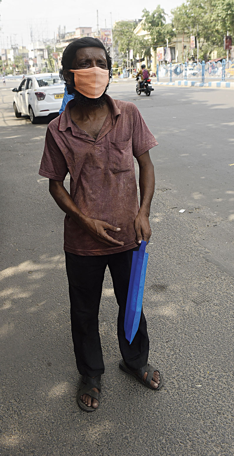 Biplab Banerjee, with two units of blood for his daughter’s dialysis in the blue packet, waits for a bus at Hazra to reach a Bagbazar nursing home