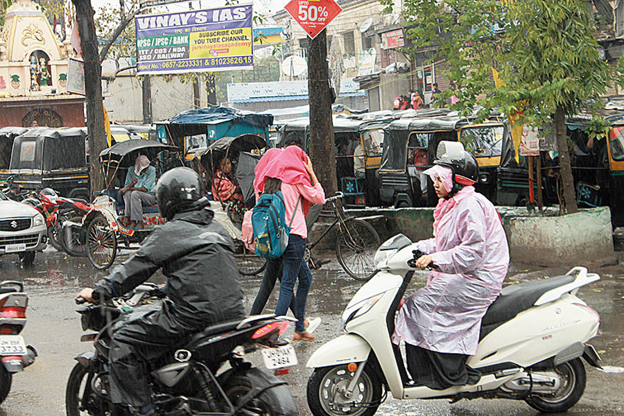 Commuters in rain gear at Sakchi in Jamshedpur on Thursday. 