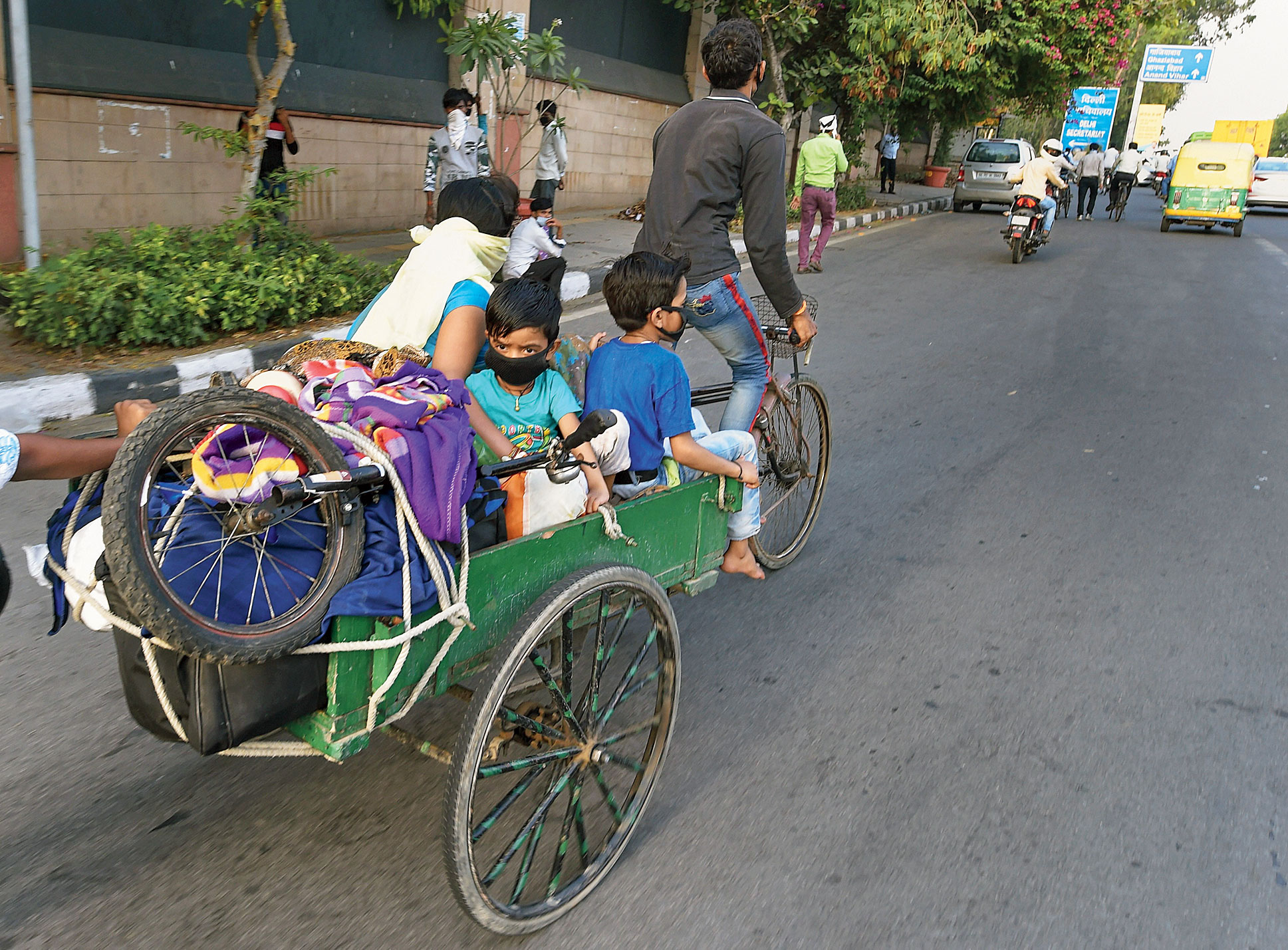 A migrant family and their belongings in a rickshaw at Vikas Marg in New Delhi on Monday.