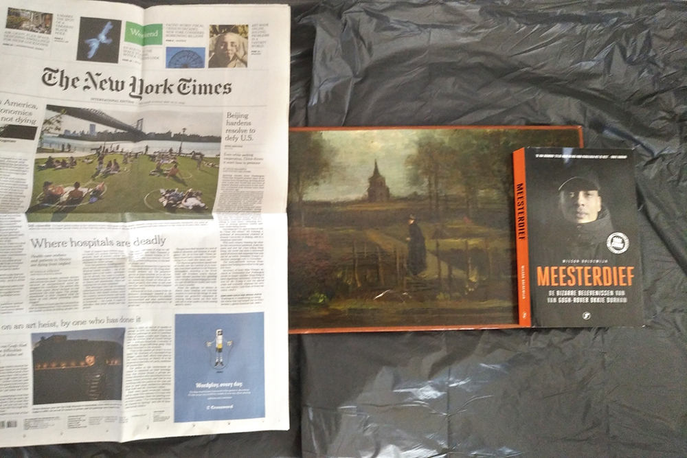 Picture released by Arthur Brand, a private Dutch art crimes detective, shows the stolen painting (centre) by Vincent van Gogh called, The Parsonage Garden at Nuenen in Spring 1884, together with a copy of The New York Times dated May 30, 2020, and a book titled Master Thief. Brand received “proof-of-life” photos of a Van Gogh painting stolen in late March from a Dutch museum in Laren, Netherlands, that was closed at the time because of the coronavirus.