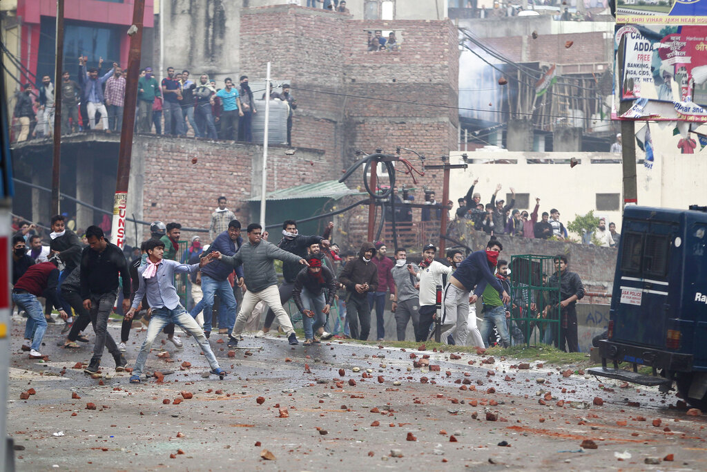 Protesters in Jammu throw stones during a clash between communities after the February 14 attack in Pulwama.