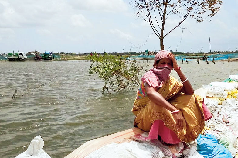 A woman sits helplessly at the inundated Bispur village in the Hingalganj area of North 24-Parganas on Sunday. 
