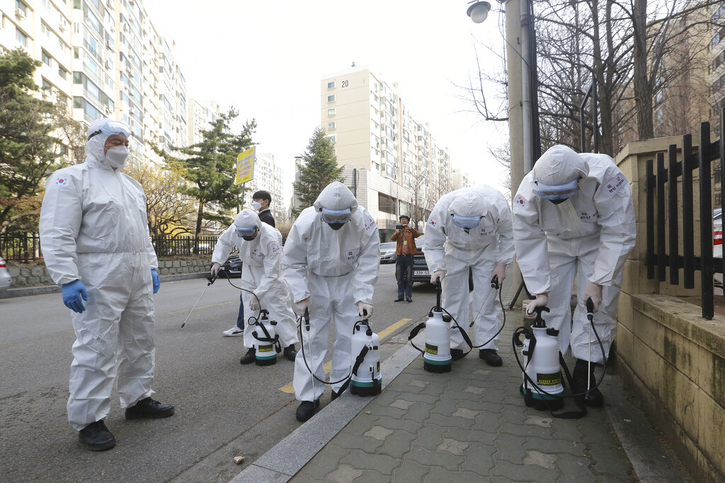 South Korean army soldiers prepare to spray disinfectant as a precaution against a new coronavirus on a street in Seoul, South Korea, Monday, March 9, 2020.