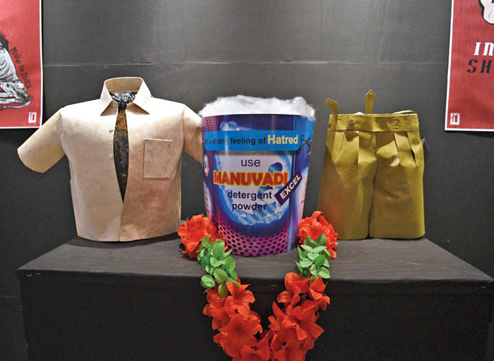 Exhibits designed by Somsankar Ray in the lobby of Uttam Mancha, the venue of Kolkata People’s Film Festival. The cardboard cut-out in the centre resembles the front of a detergent powder pack. The slogan on it — “For a strong feeling of hatred, use Manuvadi Excel detergent powder”. A shirt whose buttons are open and a pair of khaki shorts are on two sides of the cut-out. “The shirt is not fitting because the chest is too broad,” said Kasturi Basu, a member of a collective that organsised the festival.