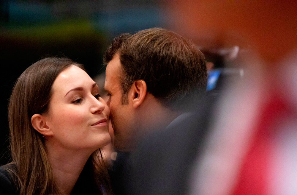 French President Emmanuel Macron greets Finnish Prime Minister Sanna Marin in Brussels on December 13