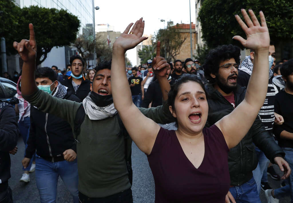 Anti-government protesters shout slogans as they march during a protest against the Lebanese central bank's governor Riad Salameh and against the deepening financial crisis, at Hamra trade street, in Beirut, Lebanon, Thursday, April 23, 2020.