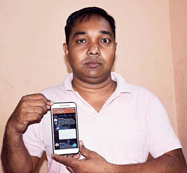 Rajan Kumar shows his tweet on PMO Twitter handle at his residence on Monday.