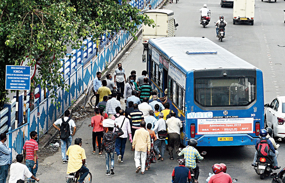 Commuters jostling to board a bus 

