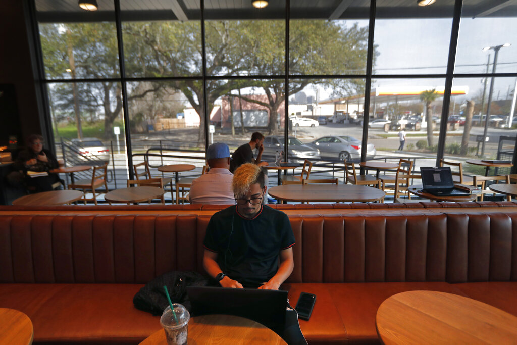 Customer Ousmane Wilson works on his computer at a Starbucks on South Claiborne Ave. in New Orleans, on January 16, 2020. Starbucks, the home of the $4 latte, is expanding a program to open coffee shops in poor neighborhoods. The Seattle-based company plans to open or remodel 85 stores by 2025 in rural and urban communities across the U.S. Each store will have event space, and Starbucks will work with local United Way chapters to offer programs like youth job training.