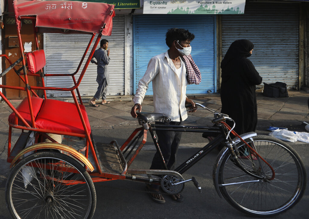 A rickshaw puller waits for customers on eve of Eid al-Fitr, at the old quarters of New Delhi, during the nationwide lockdown to curb the spread of coronavirus, Sunday, May 24, 2020.