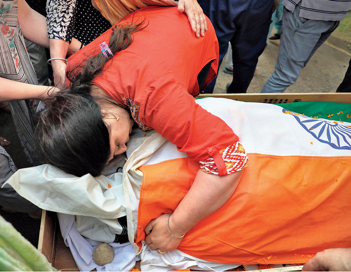 Pandita’s sister hugs his body before the funeral on Tuesday.