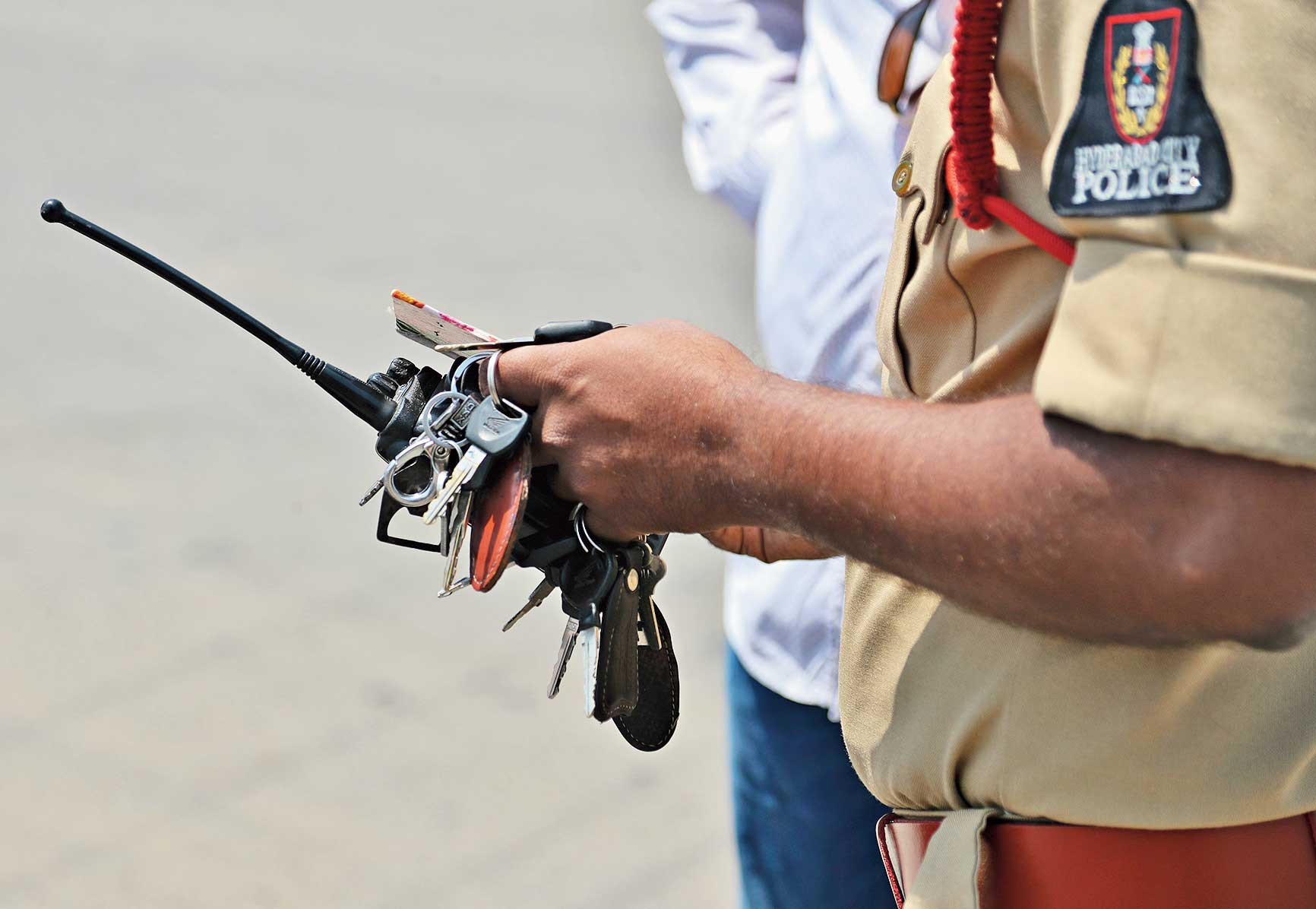 A police officer holds vehicle keys seized from people who came out on streets without valid reasons during the lockdown in Hyderabad on Tuesday.