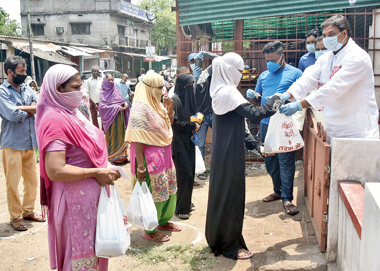 Rashid Raja Ansari, a businessman and social worker also from Wasseypur, distributes food items among the needy for Iftar in front of his residence