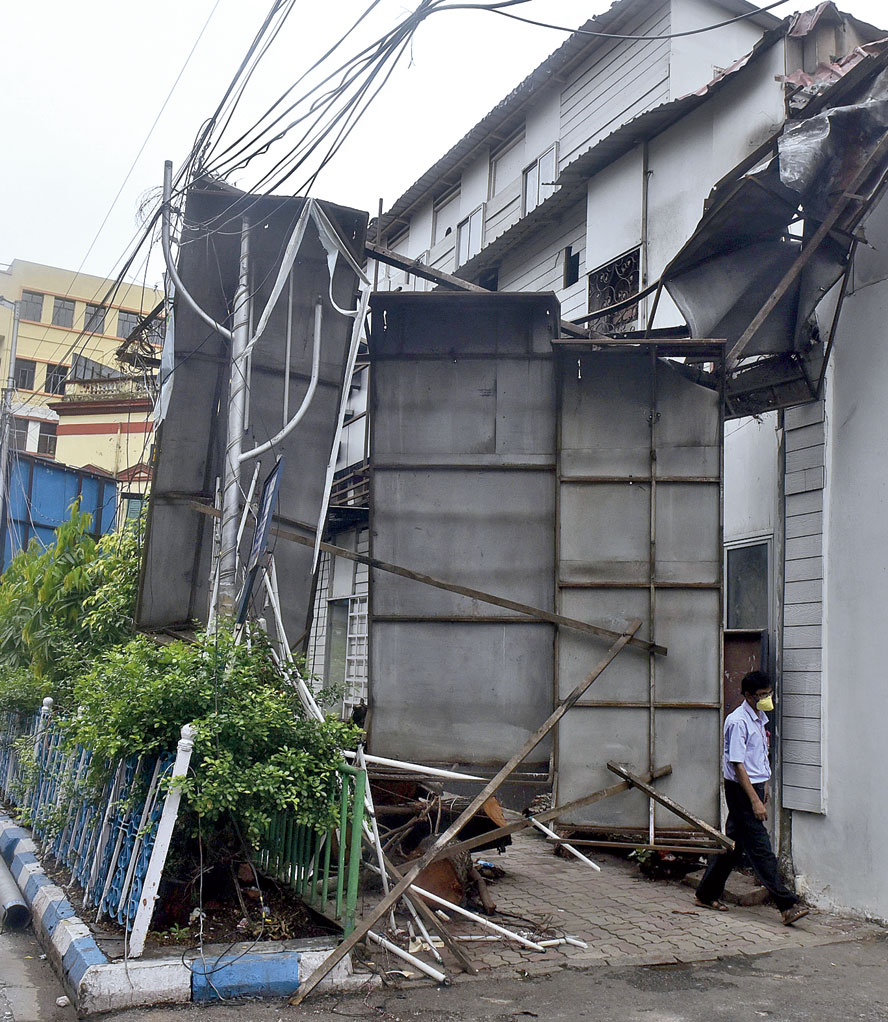 An overturned billboard blocks the footpath in front of Apeejay House on Park Street on Saturday. 