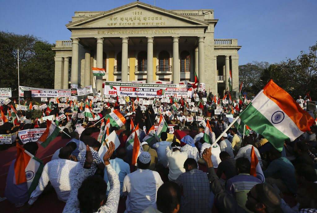 People holding national flags and placards, participate in a protest against a new citizenship law that opponents say threatens India's secular identity, in Bangalore