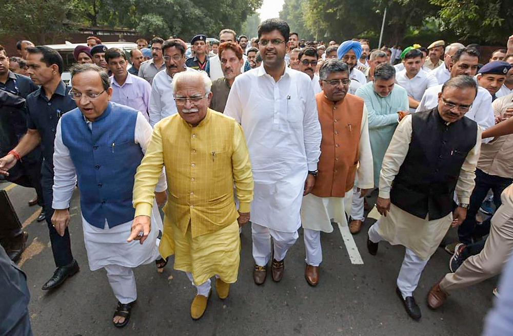 Manohar Lal Khattar and Jannayak Janta Party leader chief Dushyant Chautala on way to meet governor Satyadeo Narain Arya to stake claim to form Haryana's next government in Chandigarh on Saturday.