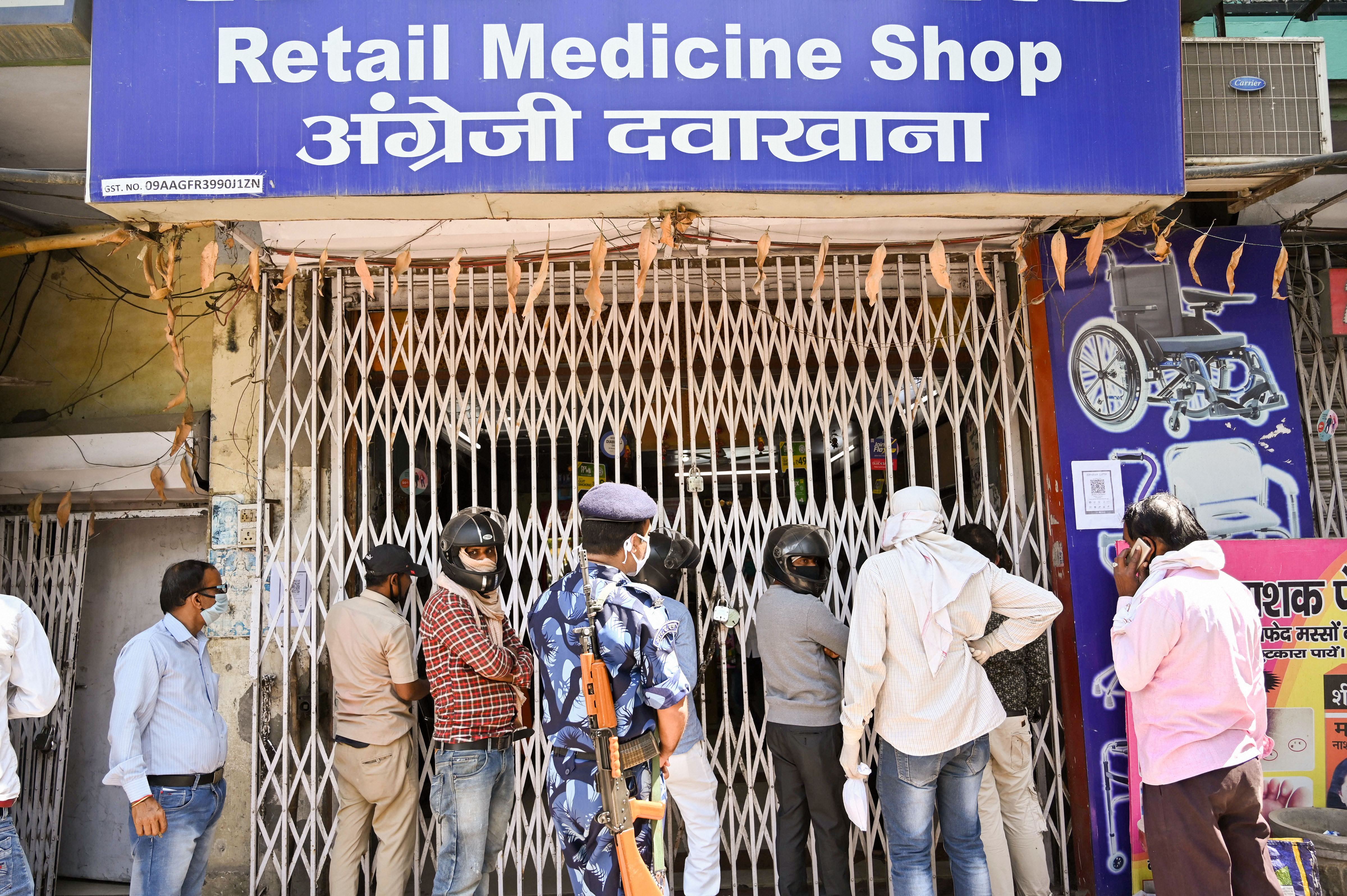 People stand outside a medical store to buy medicines during a nationwide lockdown in wake of coronavirus, in Prayagraj, Friday, April 10, 2020.
