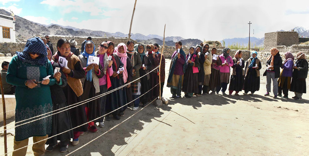 Voters stand in a queue at a polling station during the fifth phase of Lok Sabha polls at Shey village in Leh on Monday