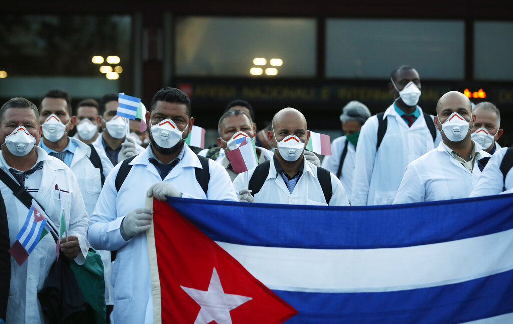 Medics and paramedics from Cuba pose upon arrival at the Malpensa airport of Milan, Italy, Sunday, March 22, 2020.