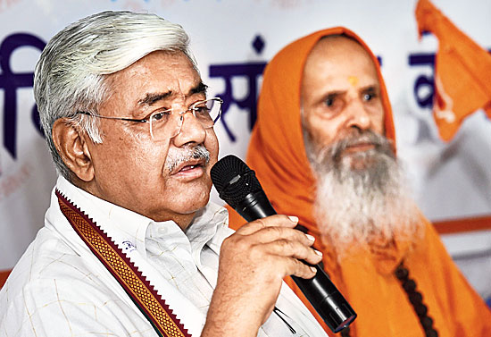 Alok Kumar addresses a news conference as Swami Parmanand looks on in New Delhi. 