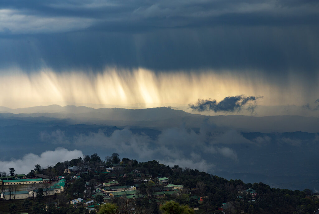 Streaks of rain and dark clouds are seen over the Kangra Valley in Dharmsala, on Saturday