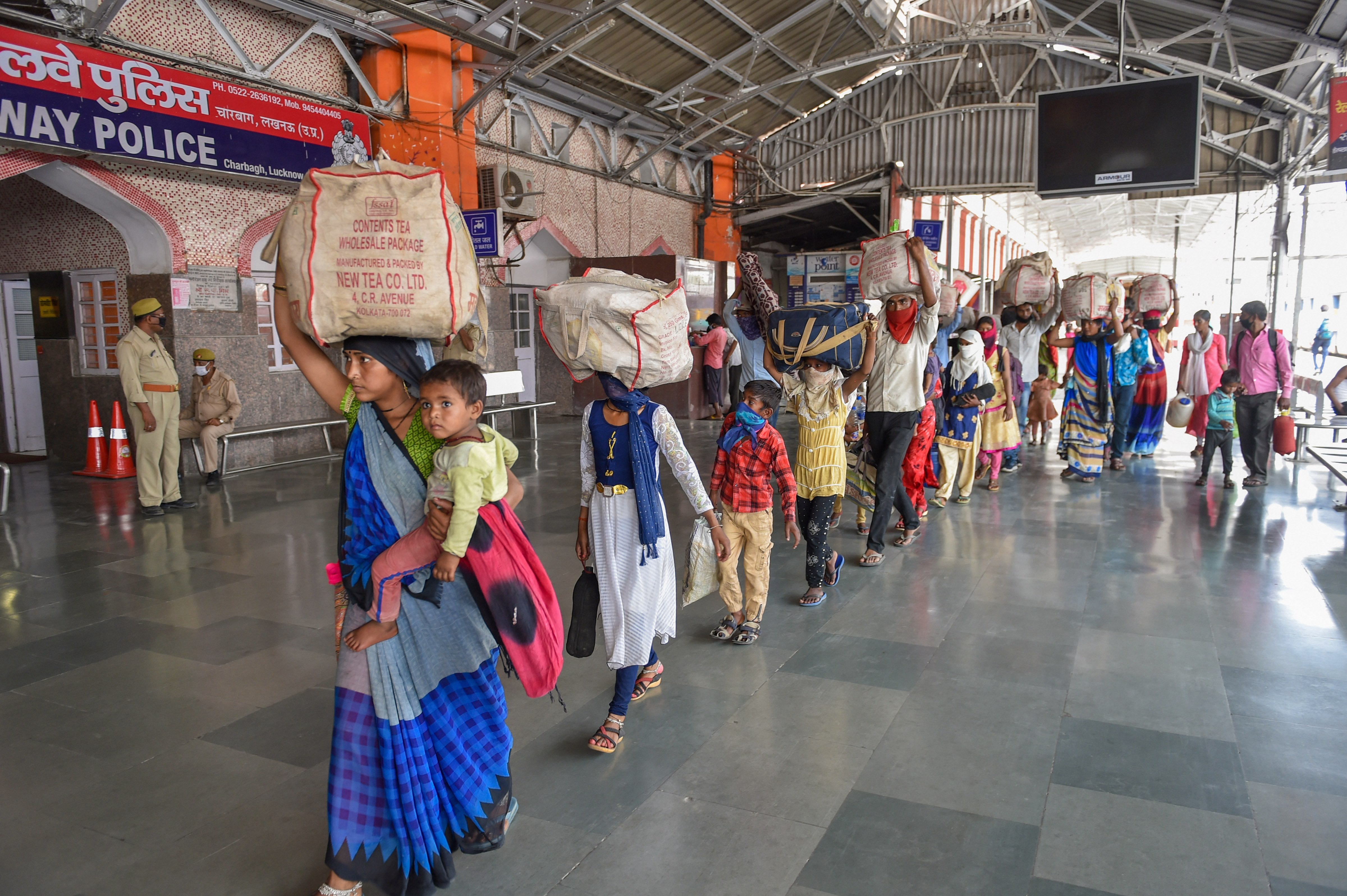 Migrants arrive to board a special train to at Charbagh railway station in Lucknow on Sunday. 