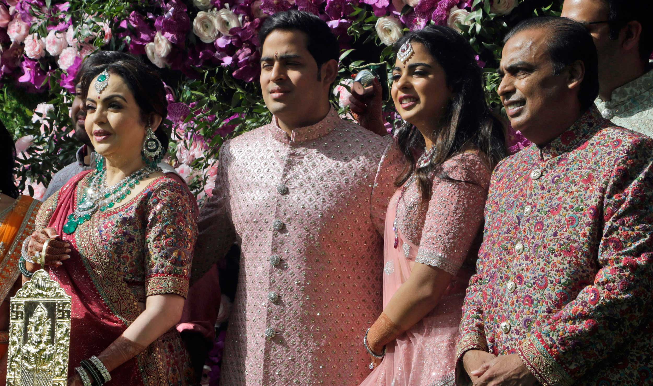 Mukesh Ambani, (right) his wife Nita Ambani, (left), son Akash Ambani and daughter Isha arrive for Akash's wedding in Mumbai, India, on Saturday. 