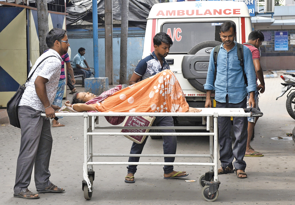 Relatives of patients push a trolley at the NRS Medical College and Hospital on Tuesday. The state of affairs at most government hospitals remain the same even as services resumed 