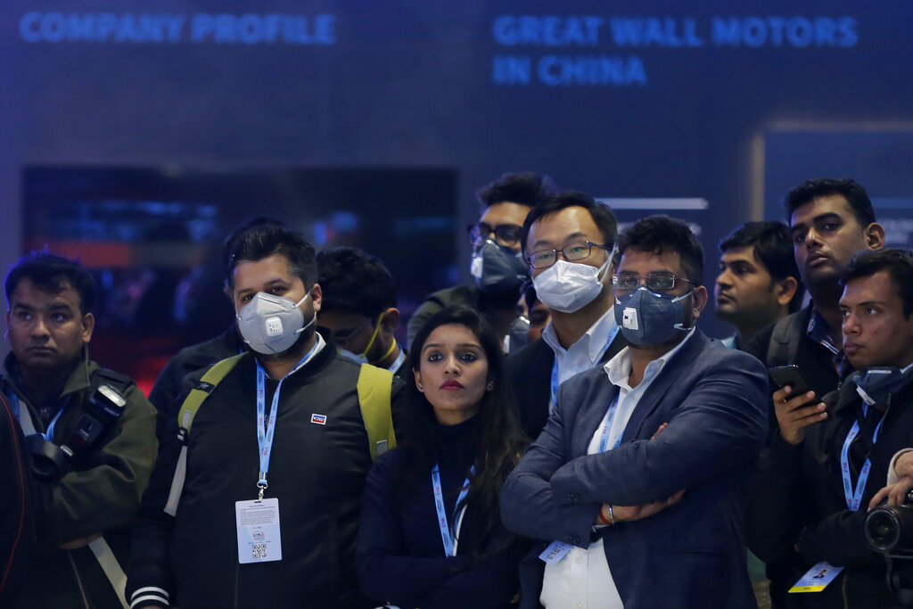 Delegates wear face mask as they attend an event at the Auto Expo in Greater Noida, near New Delhi, on Wednesday