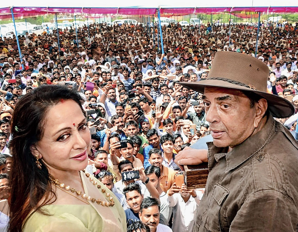 BJP candidate from Mathura, actress Hema Malini, with husband Dharmendra during an election rally in the constituency on Sunday. 