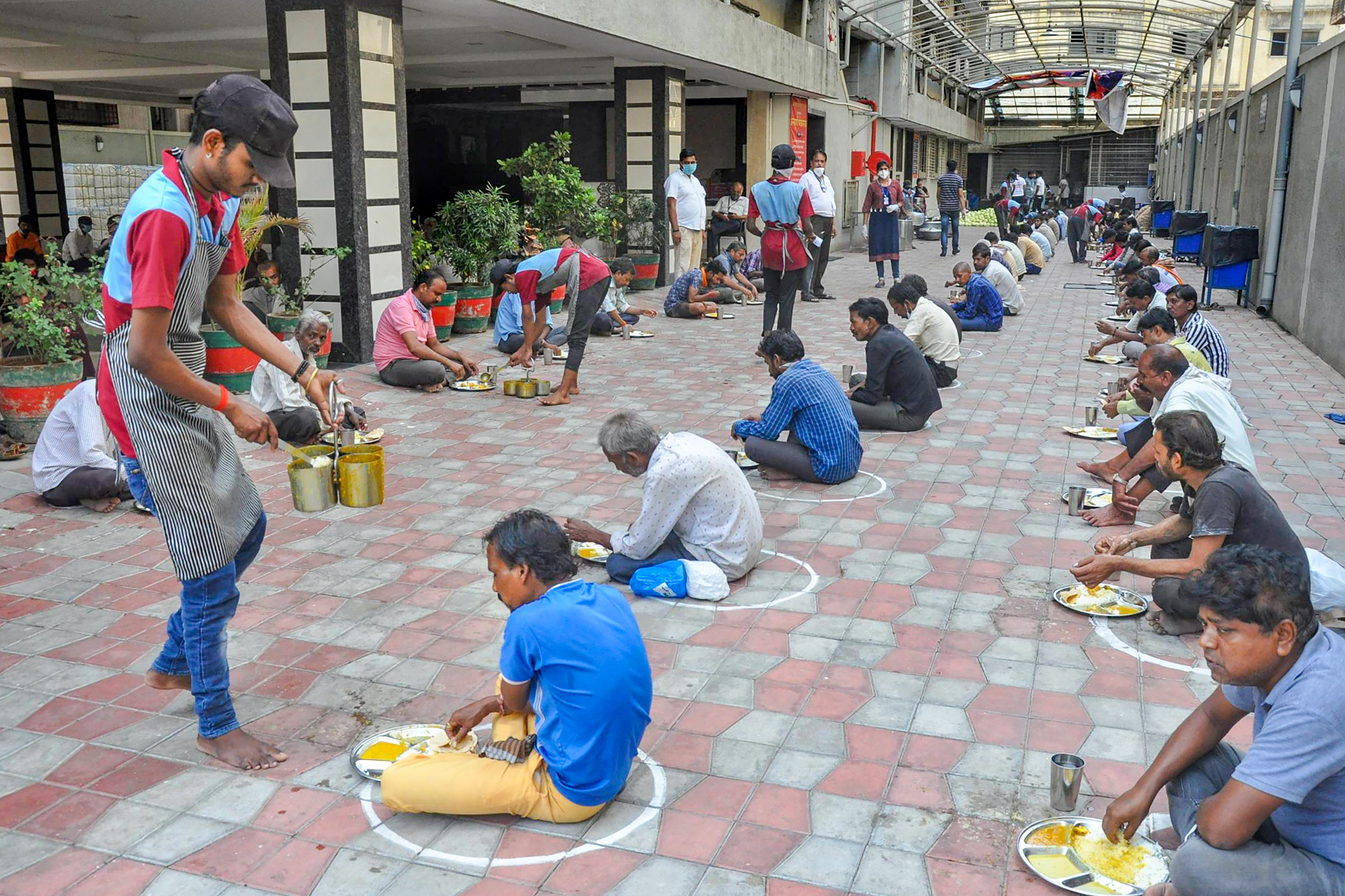 NGO members distribute food to needy people during the nationwide lockdown, imposed in wake of the coronavirus outbreak, in Surat, Thursday, April 9, 2020.